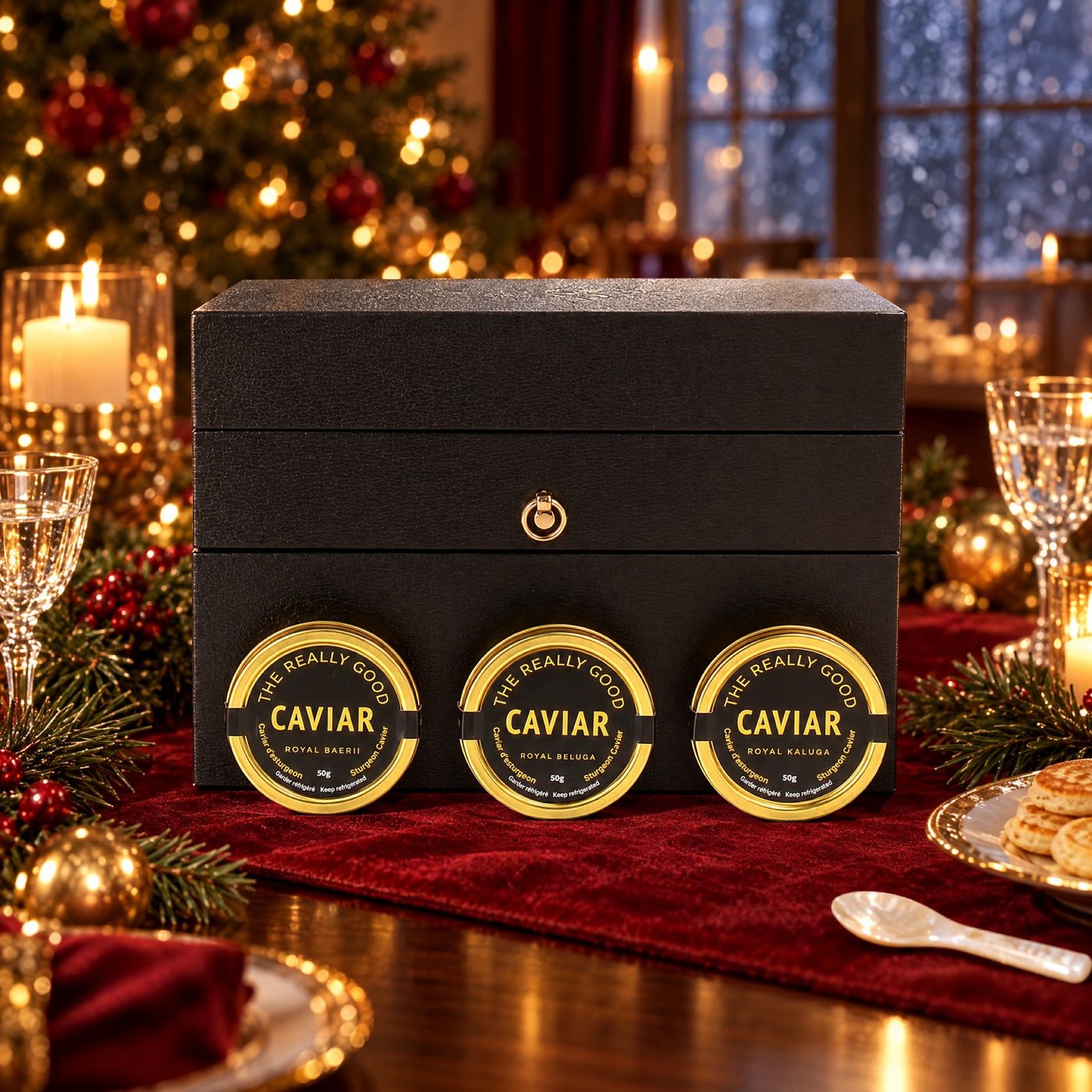 Three 50g caviar tins in front of a black gift chest on a Christmas table
