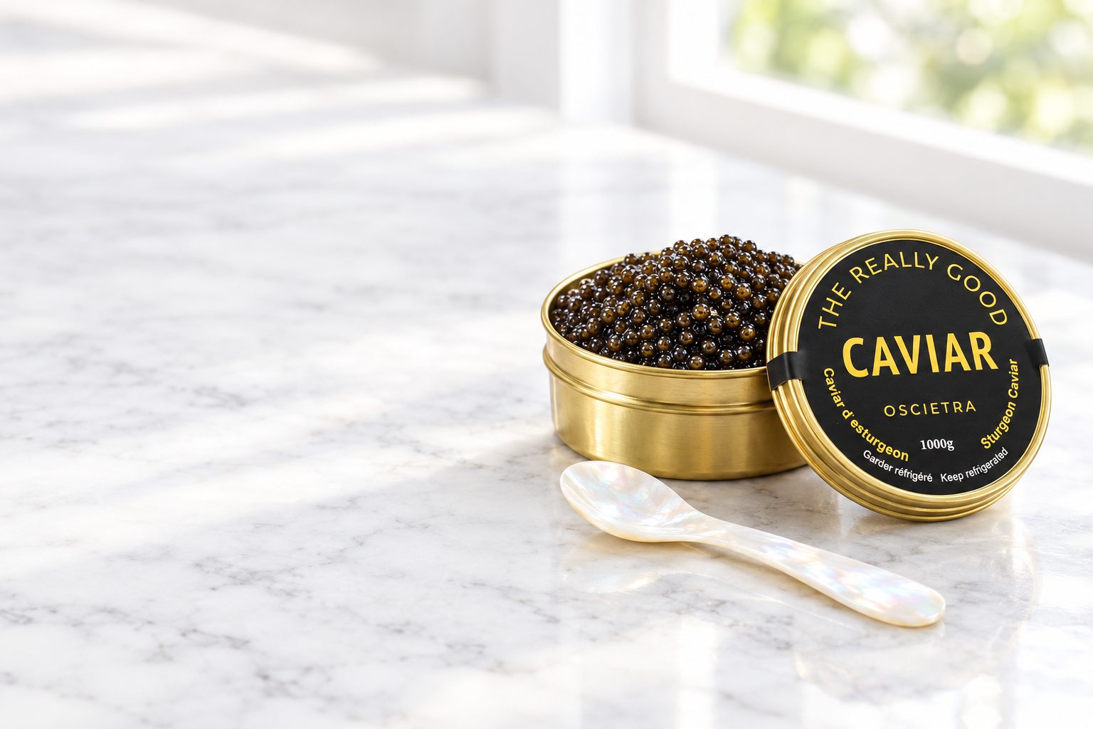 An open tin of The Really Good Caviar Oscietra on white marble with a mother-of-pearl spoon